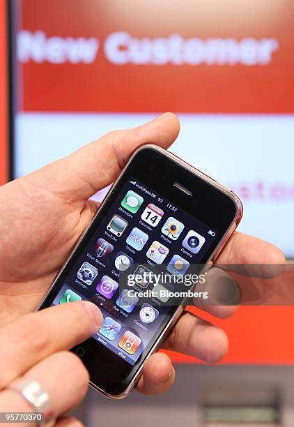 Customer examines an Apple iphone at a Vodafone store in London, U.K., on Thursday, Jan. 14, 2010. Vodafone Group Plc, the world's biggest...