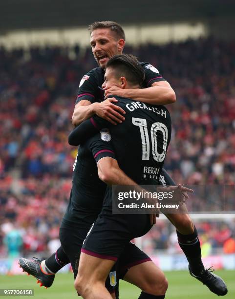 Conor Hourihane and Jack Grealish of Aston Villa mob Mile Jedinak after he scores their first goal during the Sky Bet Championship Play Off Semi...