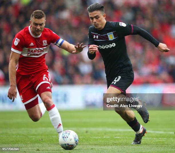 Jack Grealish of Aston Villa runs with the ball under pressure from Ben Gibson of Middlesbrough during the Sky Bet Championship Play Off Semi Final...