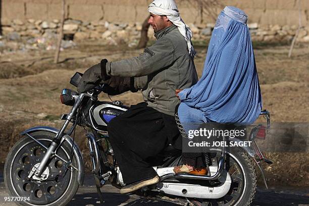 An Afghan couple travel by motor-bike near Bagram, about 60 kms from Kabul on January 11, 2010. Three US soldiers, one French trooper and a British...