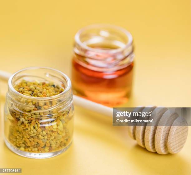 raw organic bee pollen and honey in jar. bee pollen granules. apitherapy - complejo vitamínico b fotografías e imágenes de stock