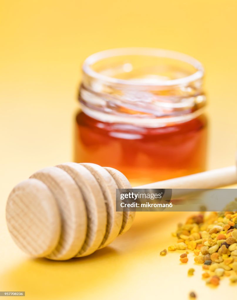 Raw organic bee pollen and honey in jar. Bee pollen granules. Apitherapy