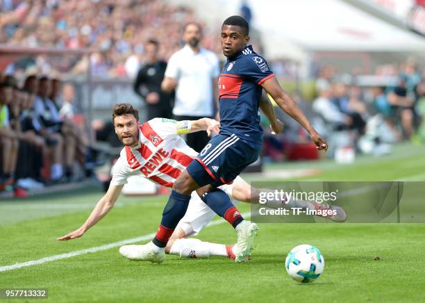 Jonas Hector of Koeln and Franck Evina of Muenchen battle for the ball during the Bundesliga match between 1. FC Koeln and FC Bayern Muenchen at...