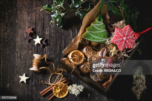 Christmas Handmade patterned gingerbreads as Christmas tree, reindeer Rudolph and snowflake shapes in wooden box over old wooden table, decorated by...