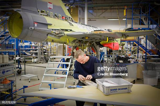 An employee works on the production of a Saab Gripen fighter jet at the company's factory in Linkoping, Sweden, on Wednesday, Jan. 13, 2010. Saab AB,...