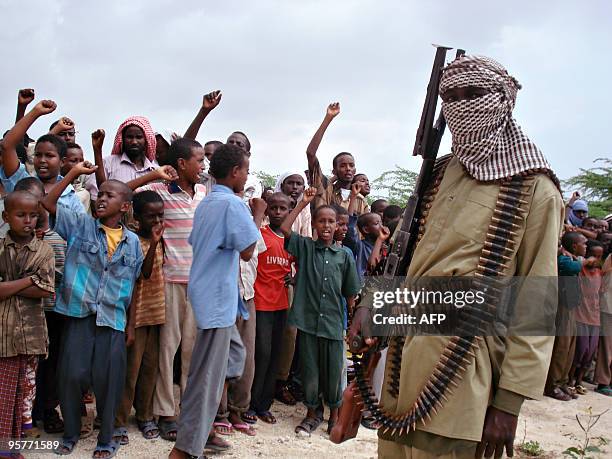 Somali boys chant as they watch hard-line Islamist fighters from Al-Shabab parade during a rally in the streets of Mogadishu on October 30, 2009. The...