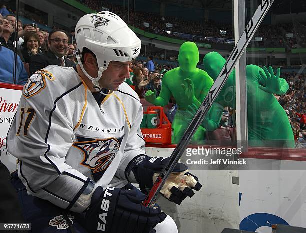 Vancouver Canuck fans wear green body suits as they taunt David Legwand of the Nashville Predators as he sits in the penalty box during their game...