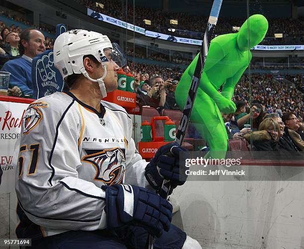 Vancouver Canuck fan wears a green body suit as he taunts Francis Bouillon of the Nashville Predators as he sits in the penalty box during their game...