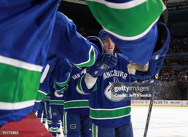 Alex Burrows of the Vancouver Canucks is congratulated by teammates after scoring during their game against the Nashville Predators at General Motors...