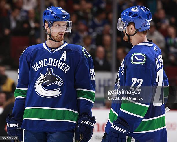Twin brothers Daniel Sedin and Henrik Sedin of the Vancouver Canucks talk to each other during their game against the Nashville Predators at General...