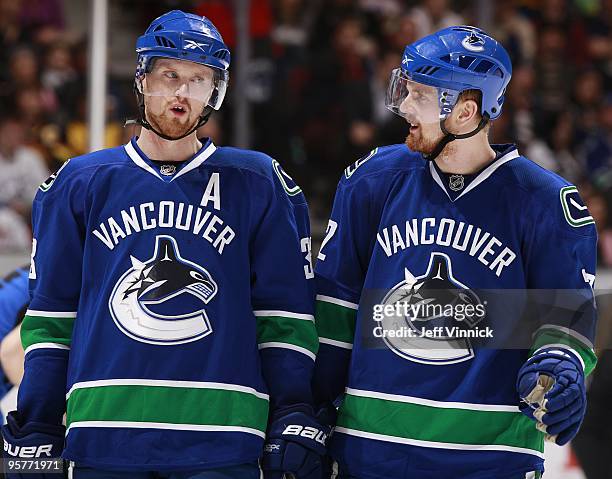 Twin brothers Daniel Sedin and Henrik Sedin of the Vancouver Canucks talk to each other during their game against the Nashville Predators at General...