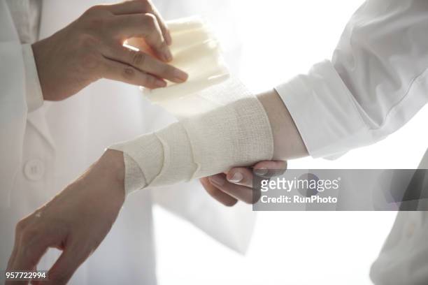 doctor bandaging patient's arm - bandage stock pictures, royalty-free photos & images