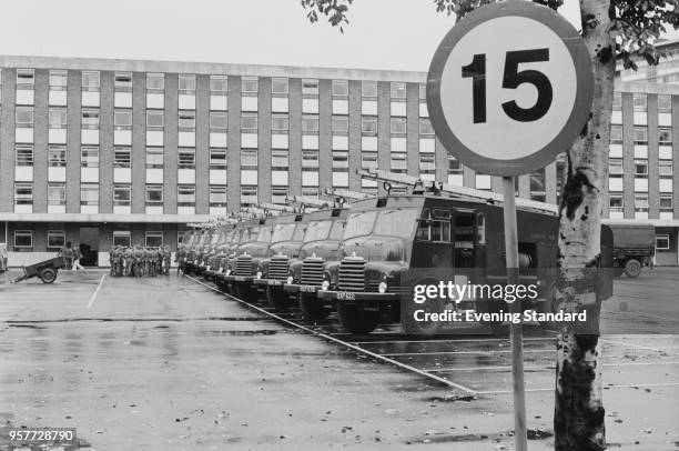 The parking lot of a fire station where Bedford RLHZ 'Green Goddess' fire engines are parked, while at the back firemen gather to strike, UK, 14th...