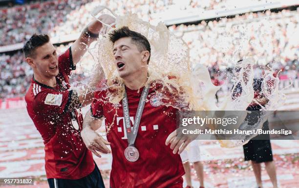 Robert Lewandowski of FC Bayern Muenchen gets a beer shower by Niklas Suele of FC Bayern Muenchen after the Bundesliga match between FC Bayern...