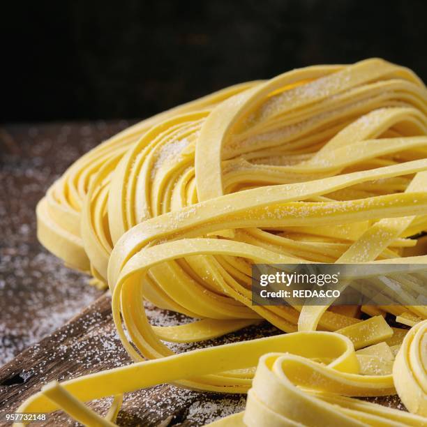 https://media.gettyimages.com/id/957732148/photo/raw-uncooked-homemade-italian-pasta-tagliatelle-with-flour-on-old-wood-cutting-board-over-dark.jpg?s=612x612&w=gi&k=20&c=9bzqsx1Nu4fEO9X4kvKiAuz-1U8XbN596CvBzSKB6hw=
