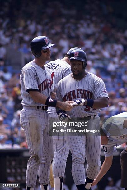 Outfielder Randy Bush congratulates outfielder Kirby Pucket of the Minnesota Twins after scoring on Puckett's two-run home run during the top of the...