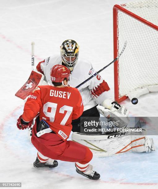 Nikita Gusev of Russia and Reto Berra of Switzerland fight for the puck during the group A match between Russia and Switzerland at the 2018 IIHF Ice...
