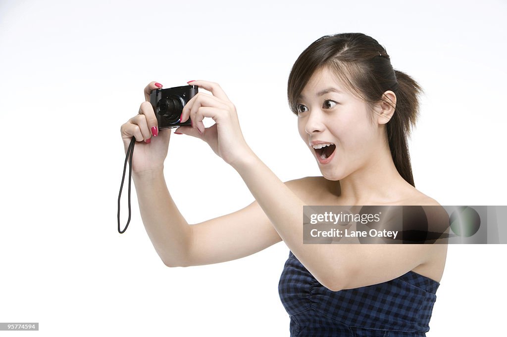 Young woman using digital camera