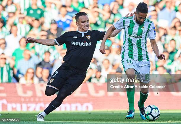 Ryad Boudebouz of Real Betis Balompie being followed by Roque Mesa of Sevilla FC during the La Liga match between Real Betis and Sevilla at Estadio...
