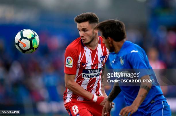 Atletico Madrid's Spanish midfielder Saul Niguez vies with Getafe's defender Damian during the Spanish league football match between Getafe and...