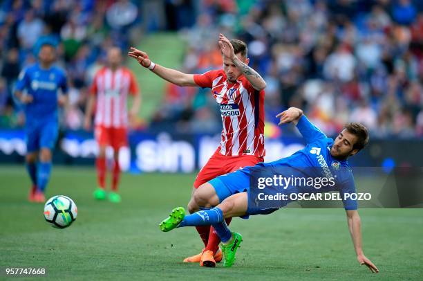 Atletico Madrid's Spanish midfielder Saul Niguez vies with Getafe's midfielder Flamini during the Spanish league football match between Getafe and...
