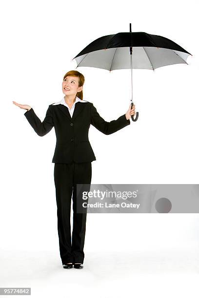 woman looking out from under umbrella - testing the water 英語の慣用句 ストックフォトと画像