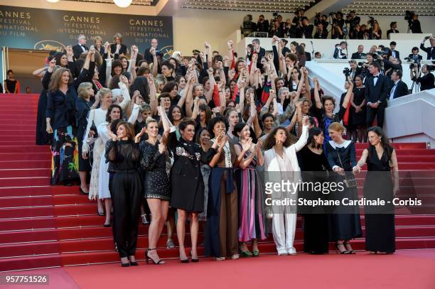 Filmmakers raise their arms as clap after Jury head Cate Blanchett with other filmmakers read a statement on the steps of the red carpet in protest...