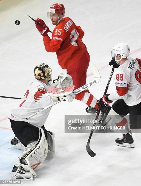 Mikhail Grigorenko of Russia and Reto Berra of Switzerland fight for the puck during the group A match between Russia and Switzerland at the 2018...