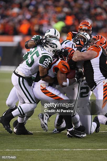 Halfback Cedric Benson of the Cincinnati Bengals is gang-tackled by Linebacker Bryan Thomas , Safety Kerry Rhodes and Defensive Tackle Howard Green...