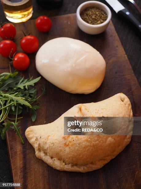 Calzone Pizza with Rocket Salad. Small Tomatoes. Oregano and Burrata Cheese. Italy.