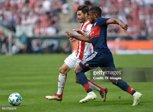 Jonas Hector of Koeln and Franck Evina of Muenchen battle for the ball during the Bundesliga match between 1. FC Koeln and FC Bayern Muenchen at...