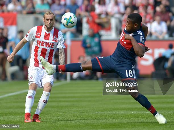 Marcel Risse of Koeln and Franck Evina of Muenchen battle for the ball during the Bundesliga match between 1. FC Koeln and FC Bayern Muenchen at...