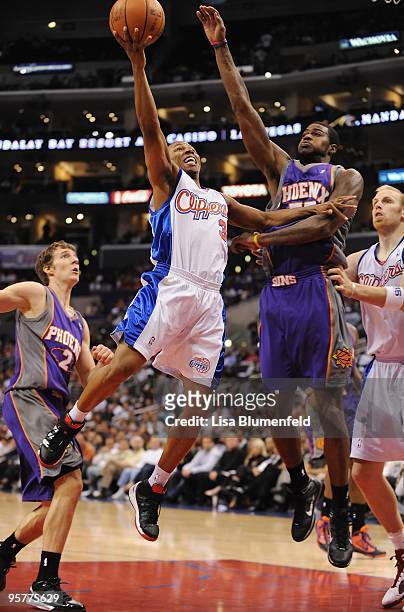 Sebastian Telfair of the Los Angeles Clippers puts a shot up against Earl Clark of the Phoenix Suns at Staples Center on October 28, 2009 in Los...