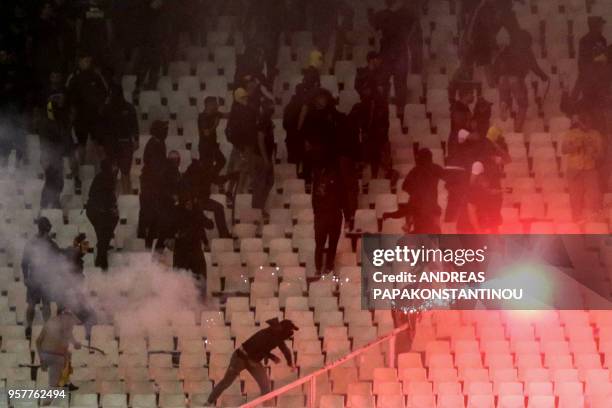 Fan throws a flare during the Greek Cup final football match between AEK FC and PAOK Salonika at the Olympic stadium in Athens on May 12, 2018.