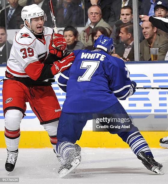 Ian White of the Toronto Maple Leafs checks Patrick Dwyer of the Carolina Hurricanes during their NHL game January 12, 2010 at the Air Canada Centre...