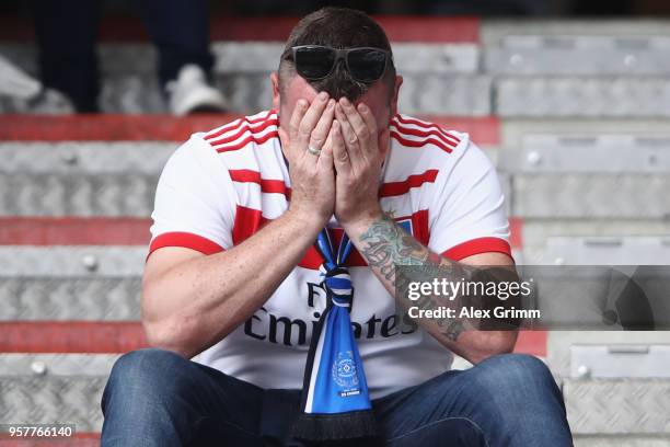 Fan of of Hamburg looks dejected after the Bundesliga match between Hamburger SV and Borussia Moenchengladbach at Volksparkstadion on May 12, 2018 in...