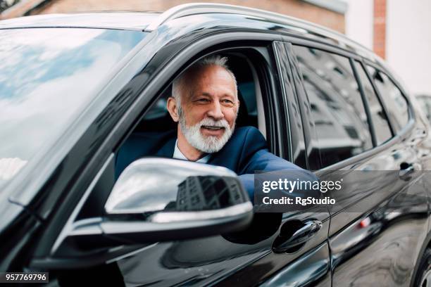 oudere zakenman in een auto - business person driving stockfoto's en -beelden