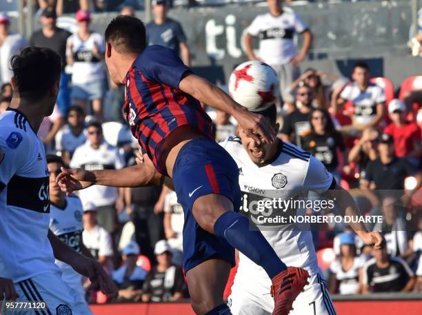 Paraguay's Olimpia player Nestor Camacho jumps for a header with Cerro Porteno's Marcos Caceres during the Paraguayan derby match in the 2018...