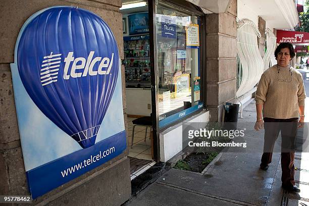 Pedestrian passes by a store for Telcel, America Movil SAB's Mexican wireless unit, in Mexico City, Mexico, on Thursday, Jan. 14, 2010. Carlos Slim's...