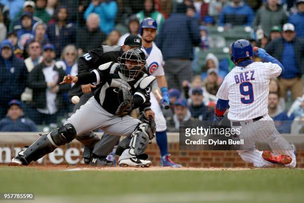 Javier Baez of the Chicago Cubs slides into home plate to score a run past Welington Castillo of the Chicago White Sox in the second inning at...