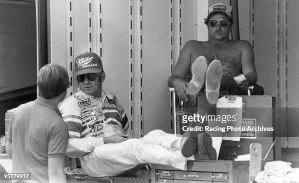 Dale Earnhardt and Bobby Allison rest in the shade during the time trial in Nashville.