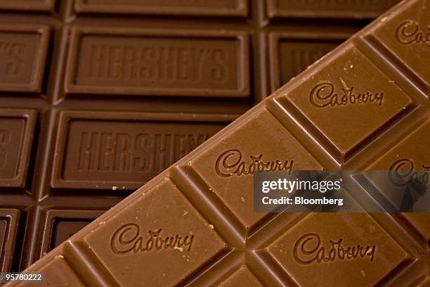 Cadbury Plc chocolate bar sits on top of a Hershey Co. Hershey's chocolate bar as they are displayed for a photograph in New York, U.S., on Thursday,...