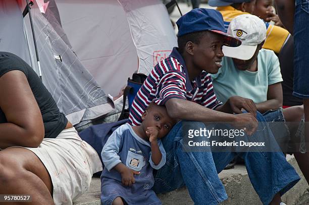 Refugees rest in the streets following a powerful earthquake that left much of the capital city in ruins January 14, 2010 in Port-au-Prince, Haiti. A...