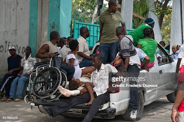Pickup truck carrying wounded arrives at a hospital following a powerful earthquake that left much of the capital city in ruins January 14, 2010 in...