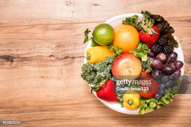 gezonde groenten en fruit in kom op houten achtergrond - fruitschaal stockfoto's en -beelden