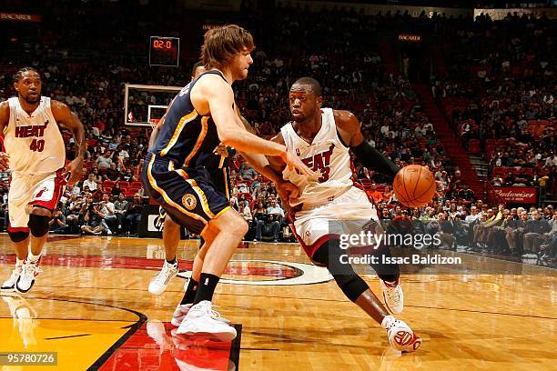 Dwyane Wade of the Miami Heat moves the ball against Josh McRoberts of the Indiana Pacers during the game on December 27, 2009 at American Airlines...