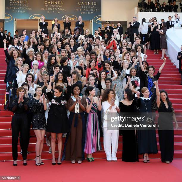 Filmmakers raise their arms as clap after Jury head Cate Blanchett with other filmmakers read a statement on the steps of the red carpet in protest...