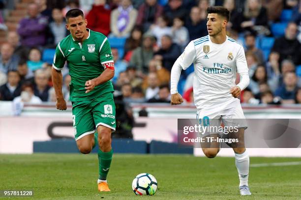 Marco Asensio of Real Madrid and a player of Leganes battle for the ball during the La Liga match between Real Madrid and Leganes at Estadio Santiago...