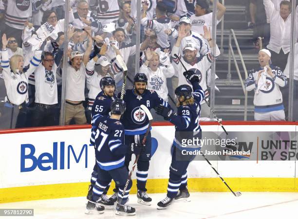 Dustin Byfuglien of the Winnipeg Jets is congratulated by his teammates after scoring a first period goal against the Vegas Golden Knights in Game...