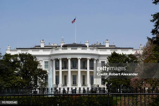An American flag flies over the south facade of the White House in Washington, D.C. Additional security fences and barriers were added along the...